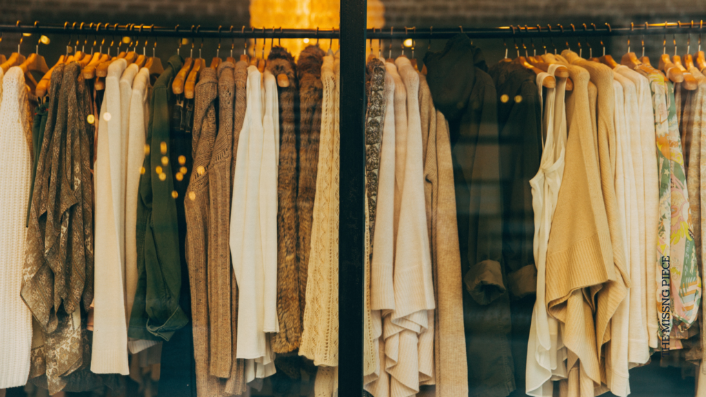 Clothes rack with beige, black and green shirts and sweaters